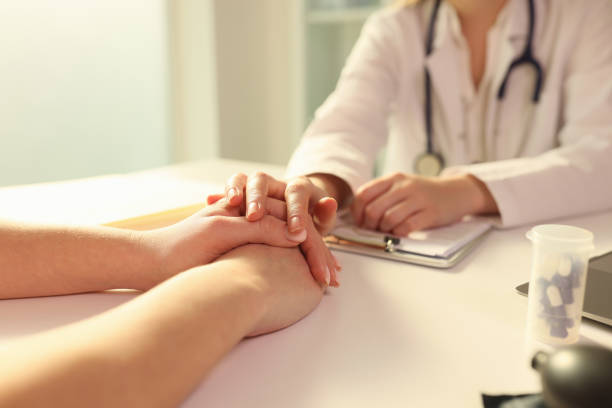 Doctor holding patient’s hand during medical consultation