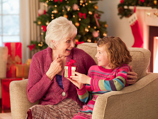 Granddaughter giving gift to grandmother at Christmas